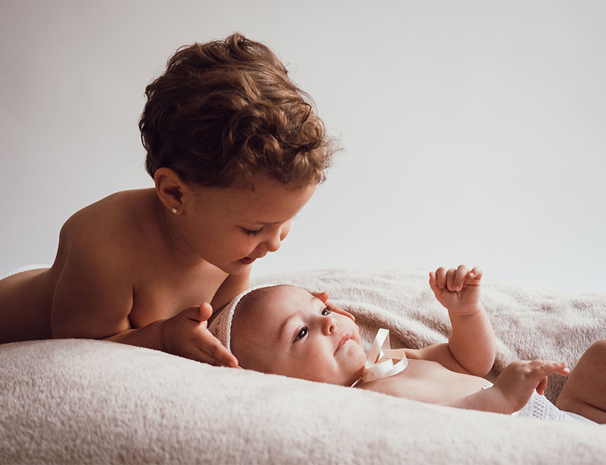 Un niño y un bebé sobre la cama