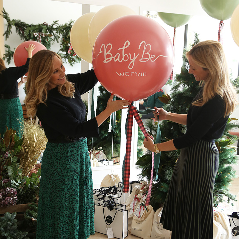 Dos mujeres con un cesto con globos de regalo
